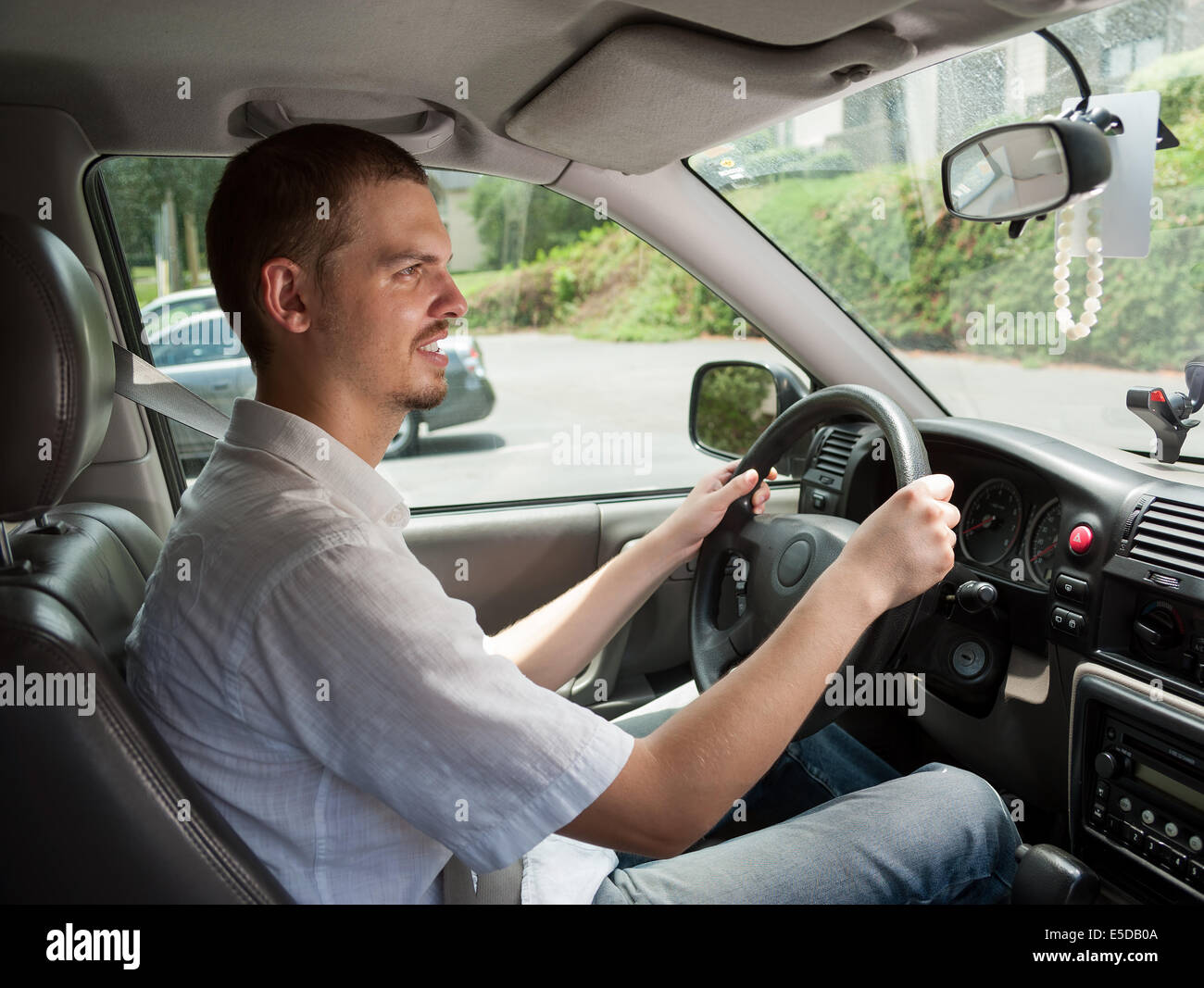 Young caucasian driver goes safe and by rules Stock Photo