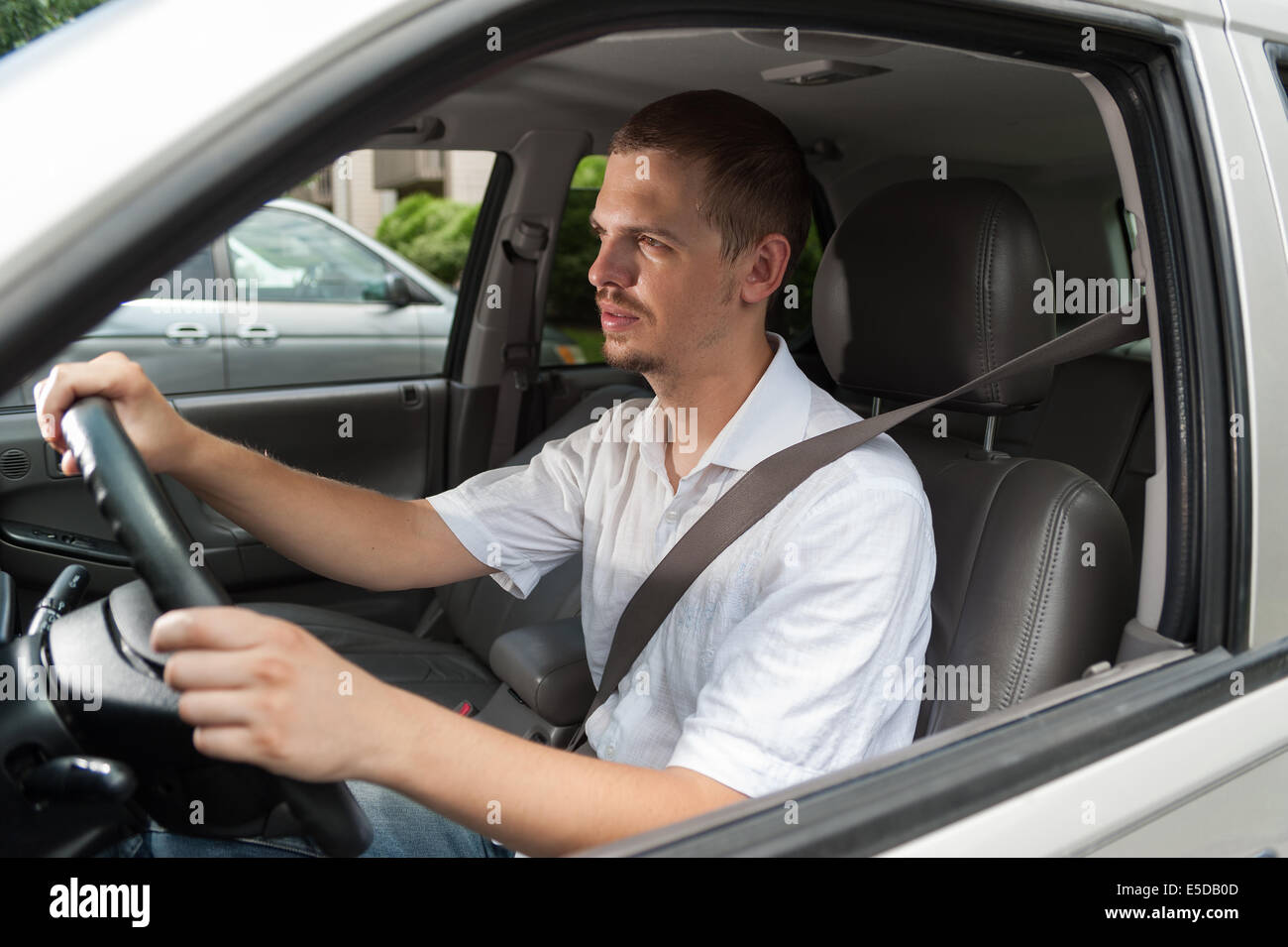 Young caucasian driver goes by rules and safe Stock Photo