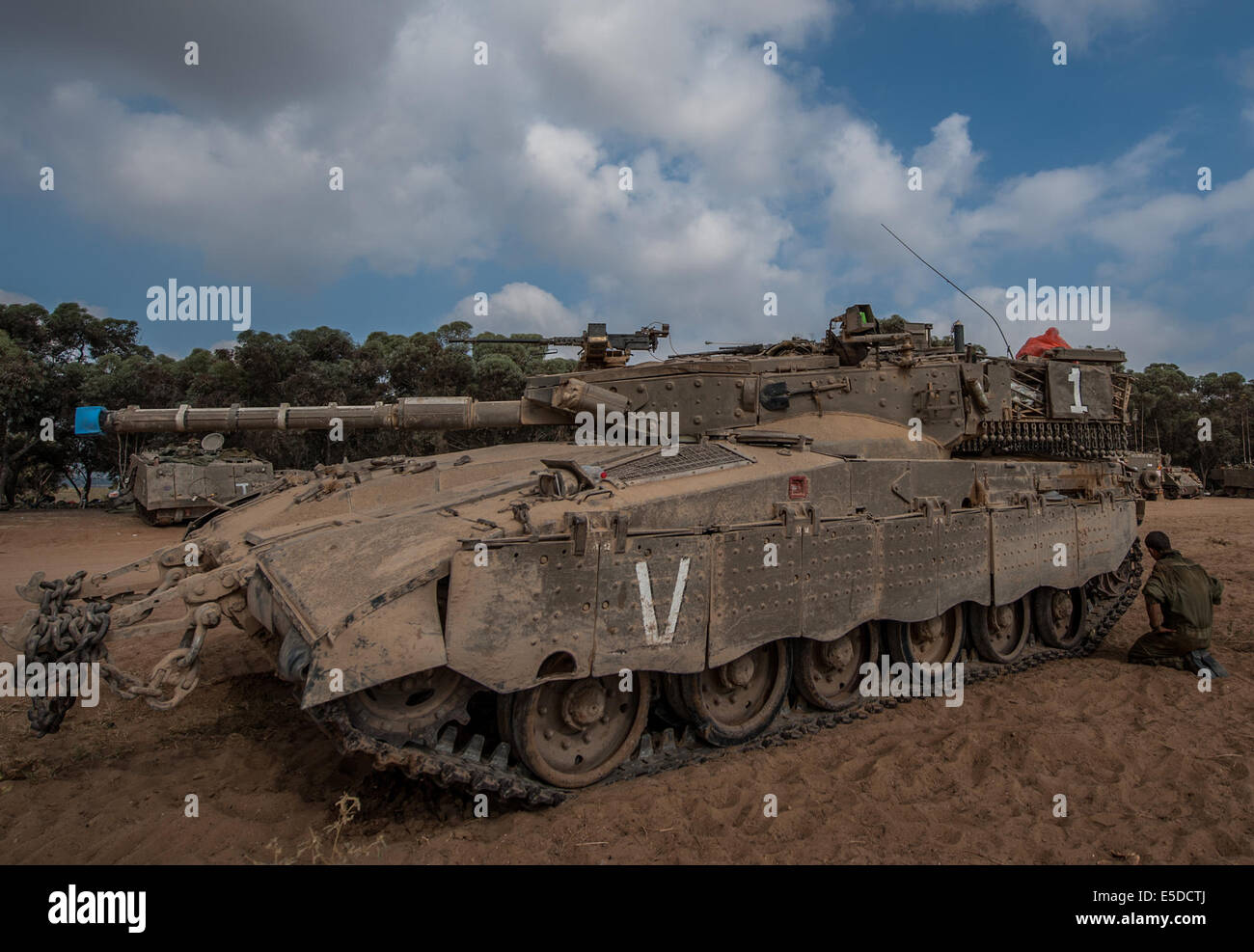 Gaza Border. 28th July, 2014. An Israeli soldier checks the caterpillar track of a Merkava tank at an army deployment area in southern Israel near the border with the Gaza Strip, on July 28, 2014. Israel's top political and defense leadership on Monday night defied international calls for a cease-fire in the Gaza Strip, determining to continue the massive offensive there until the risk posed by Gaza militant groups is "neutralized." Credit:  Li Rui/Xinhua/Alamy Live News Stock Photo
