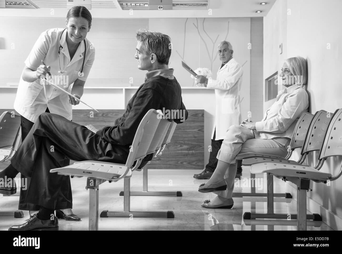 Doctors and patients in hospital waiting room. Stock Photo