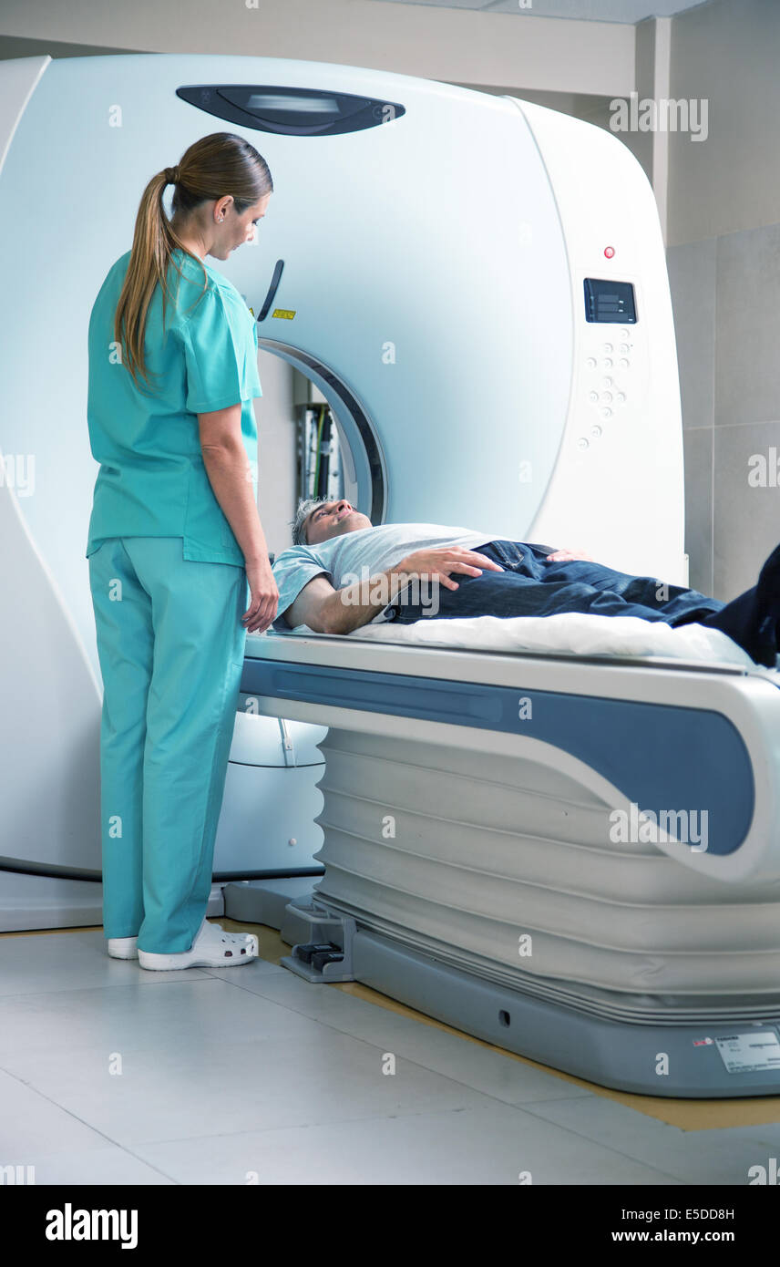 Open MRI scanner with man in 40s undergoing test. Stock Photo