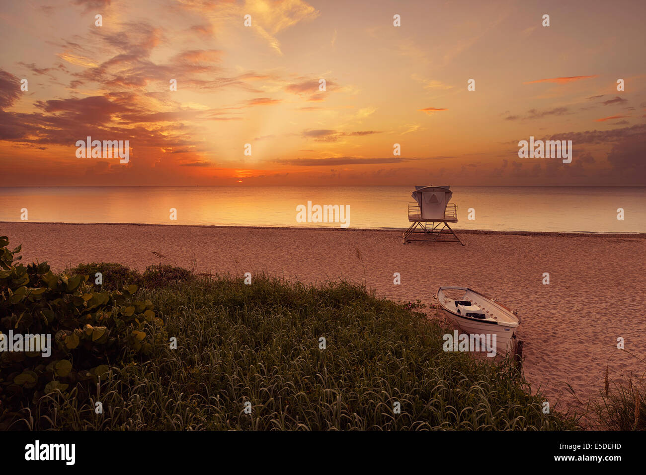 Tropical beach at beautiful sunrise. Nature background with lifeguard station and boat at Palm Beach, Florida, United States. Stock Photo