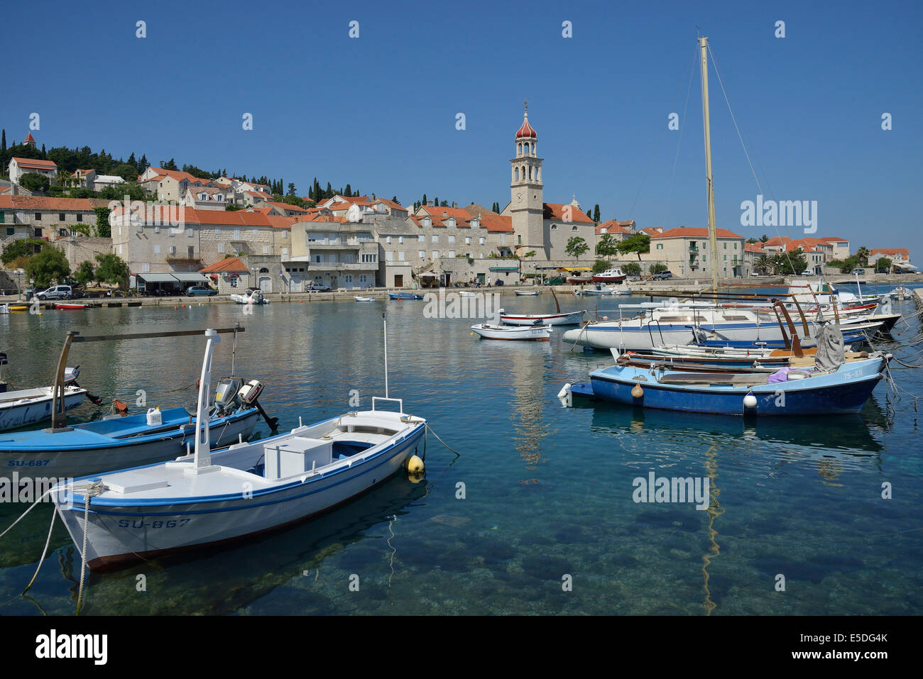 Fishing boats in the harbour in front of the church of Sveti Ivan, St Ivan, Sutivan, Island of Brač, Dalmatia, Croatia Stock Photo