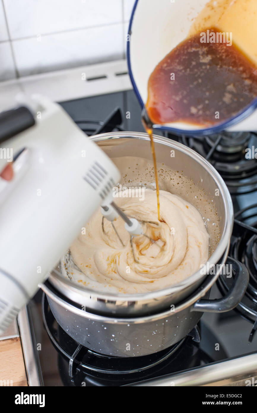 Stirring beaten egg white in bain-marie while adding caramel, elevated view Stock Photo