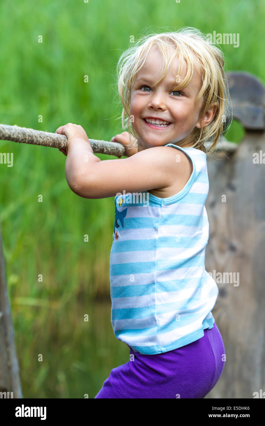 Little girl balancing on a wooden raft Stock Photo - Alamy