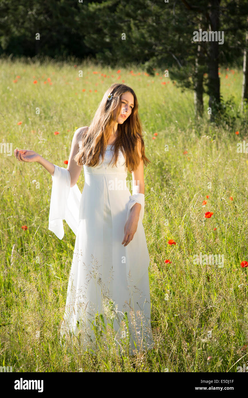 Portrait of teenage girl wearing white dress standing on meadow Stock ...