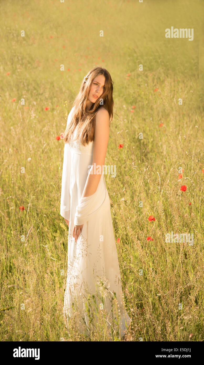 Portrait of teenage girl wearing white dress standing on meadow Stock ...