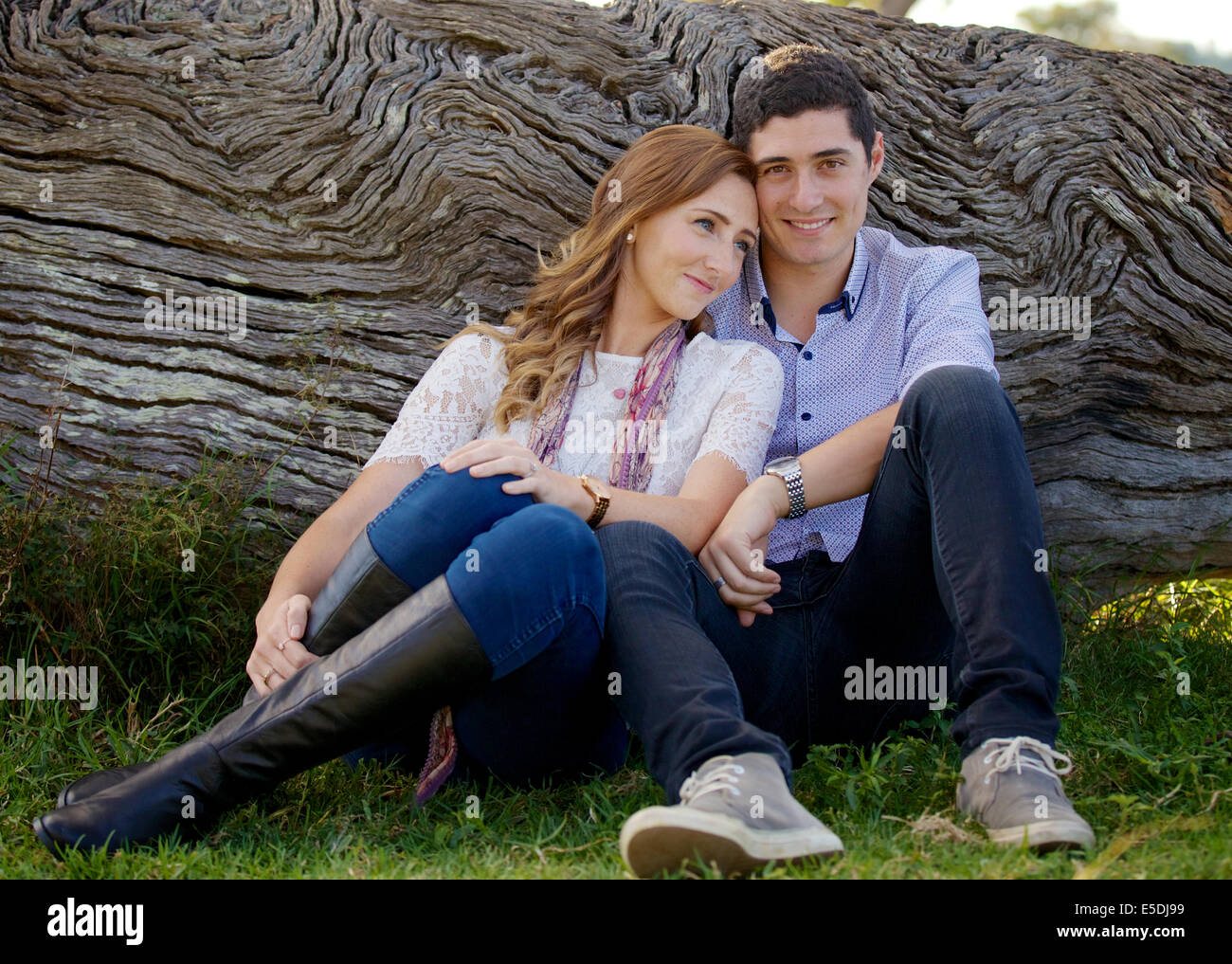 a couple in love resting near a log Stock Photo