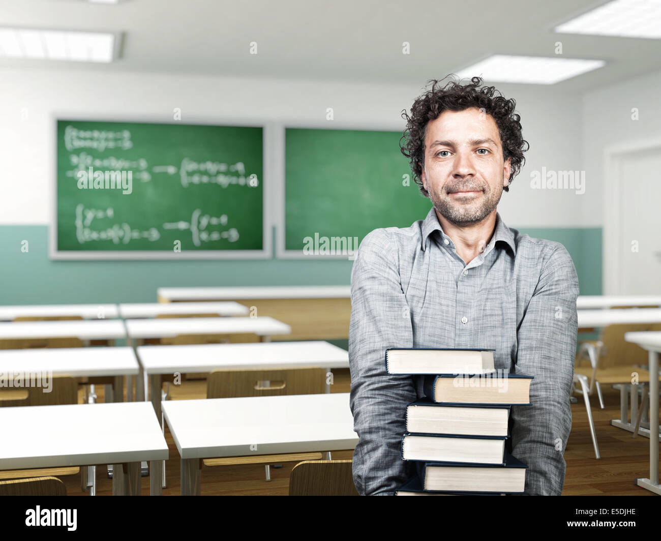 portrait of student with books in classroom Stock Photo