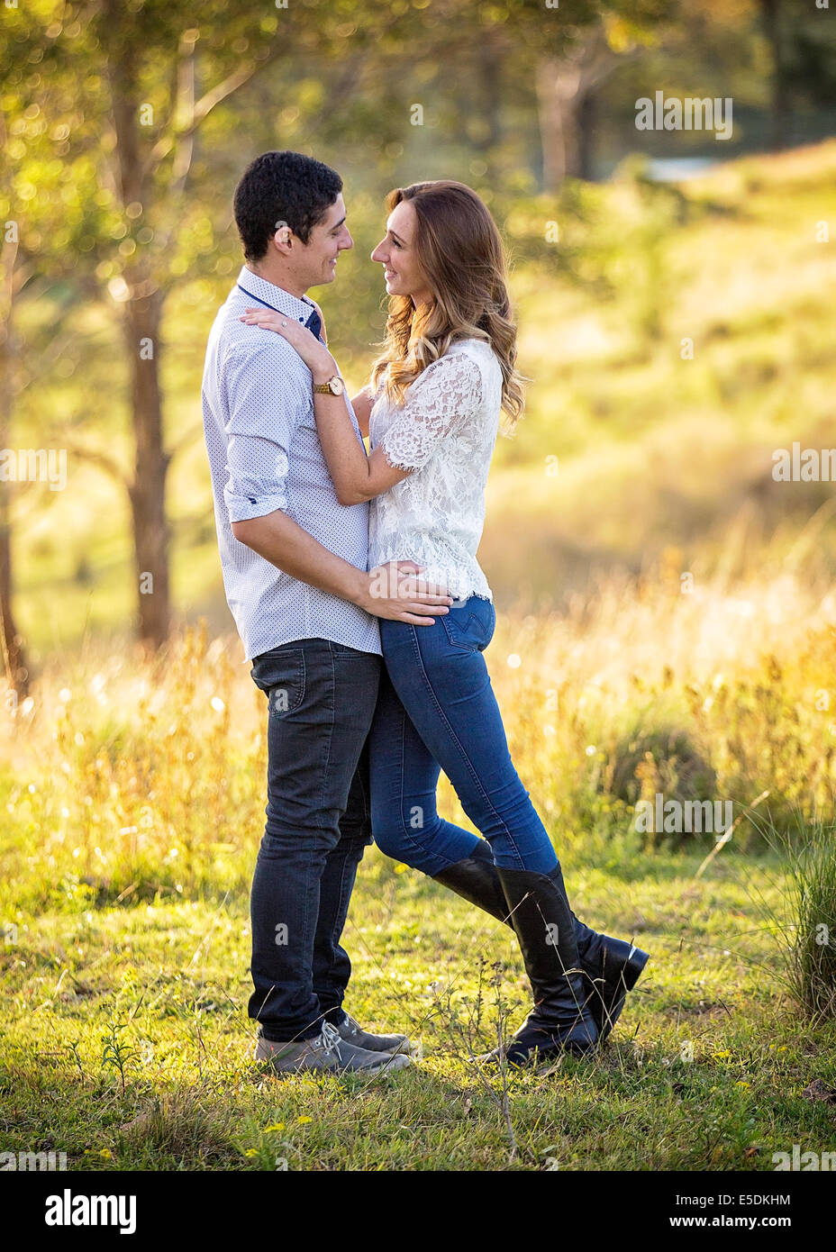 young couple standing in embrace in a rural setting Stock Photo