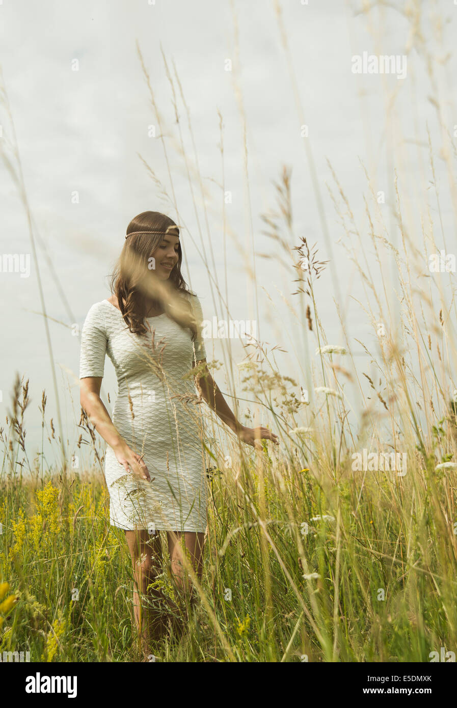 Portrait of smiling young woman standing on flower meadow Stock Photo ...
