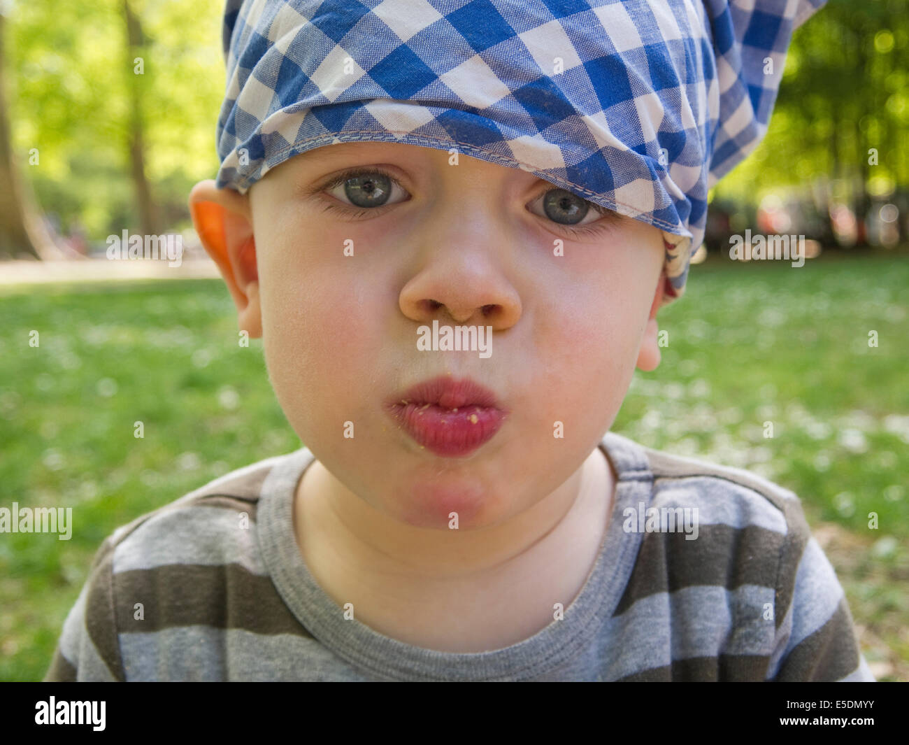 Baby boy wearing headscarf eating Stock Photo