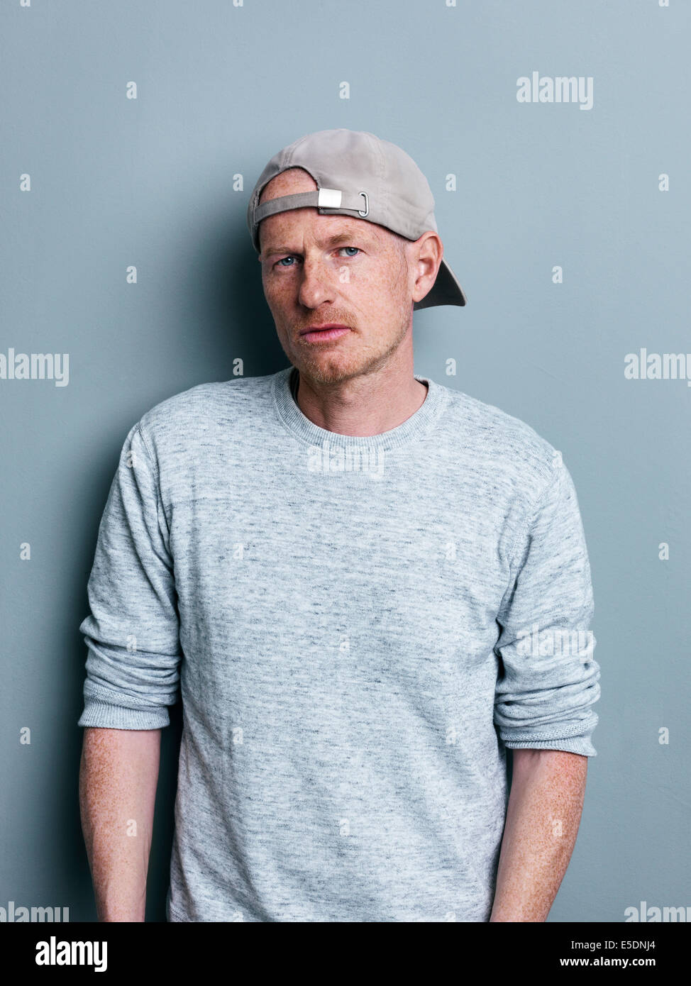 Portrait of man with basecap in front of gray background Stock Photo