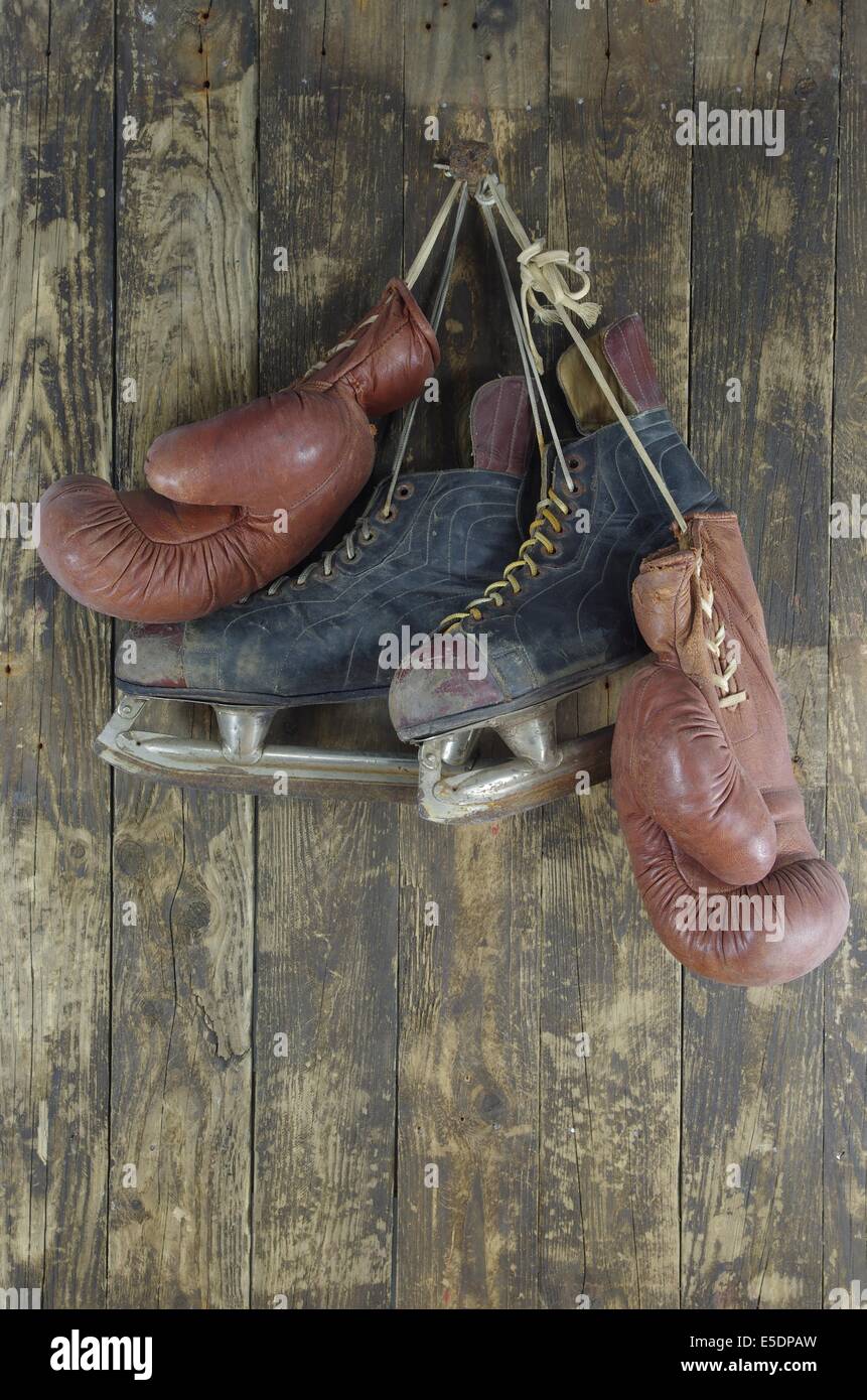 old boxing  and and hockey skates pendant on peg Stock Photo