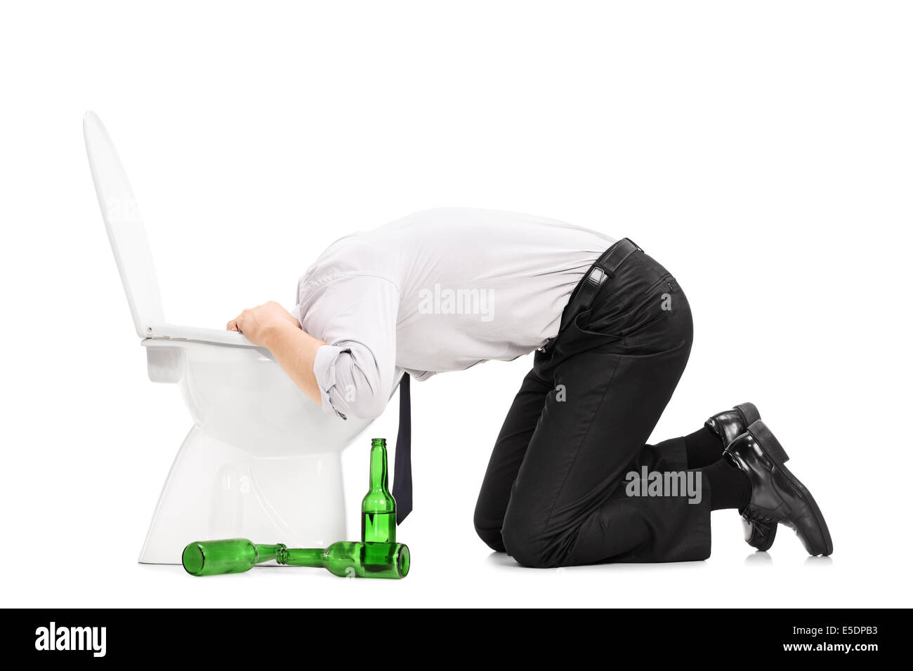 Drunk man throw up in a toilet with empty beer bottles next to him Stock Photo