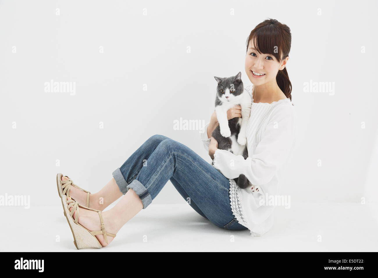 Japanese young woman in jeans and white shirt with cat Stock Photo