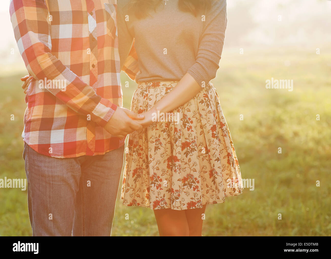 Happy couple holding hands looking in the sunset Stock Photo - Alamy