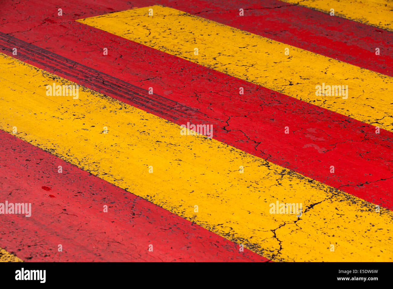 Pedestrian crossing road marking with yellow and red lines Stock Photo