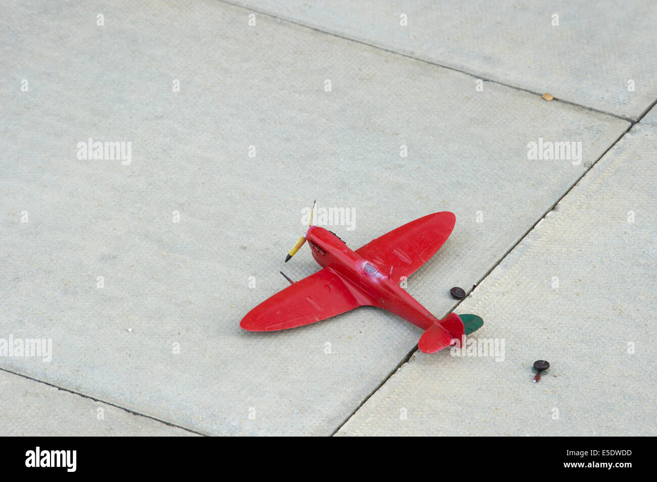 broken red toy spitfire landing gear torn off Stock Photo