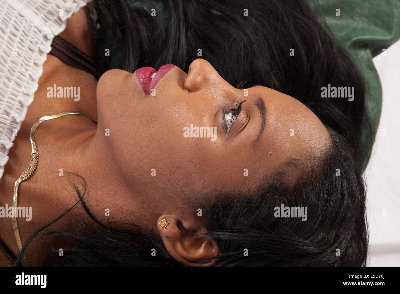 Pretty black woman reclining with a happy, pleased smile Stock Photo