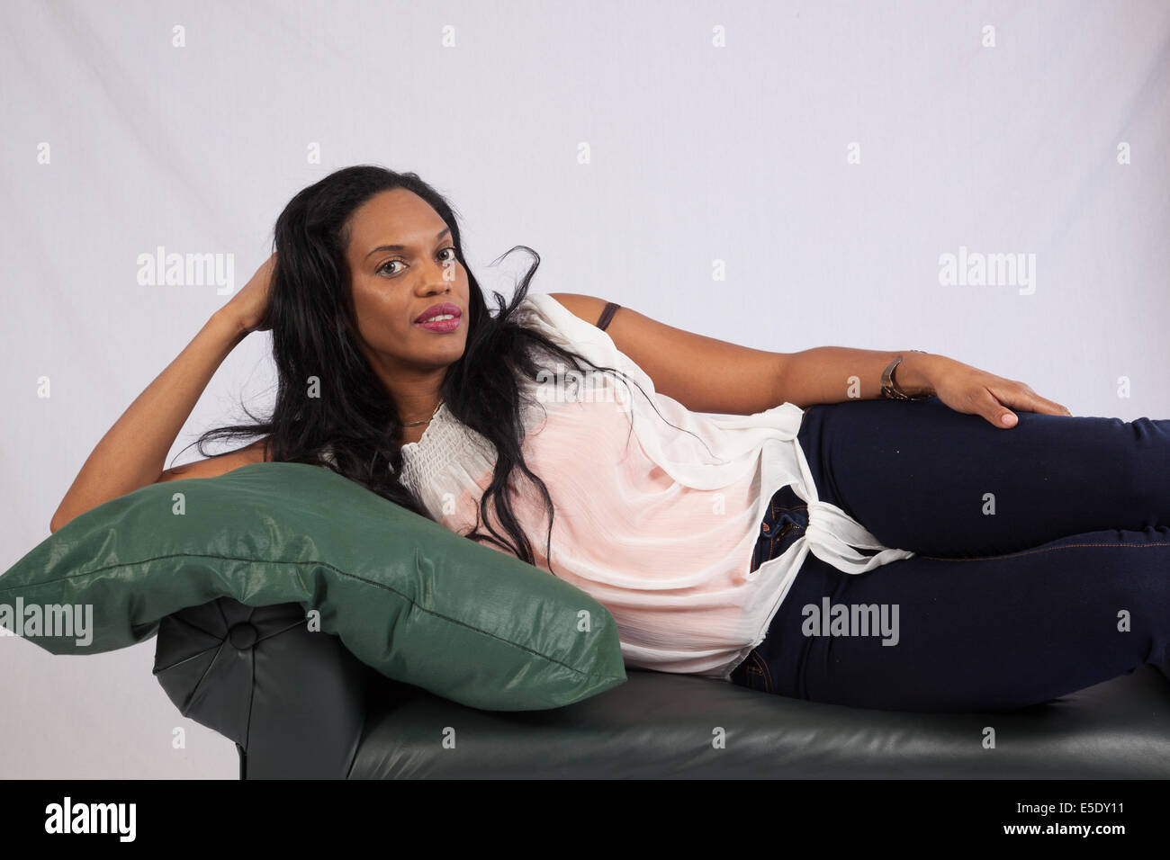 Pretty black woman reclining and looking at the camera  with a friendly,  smile Stock Photo