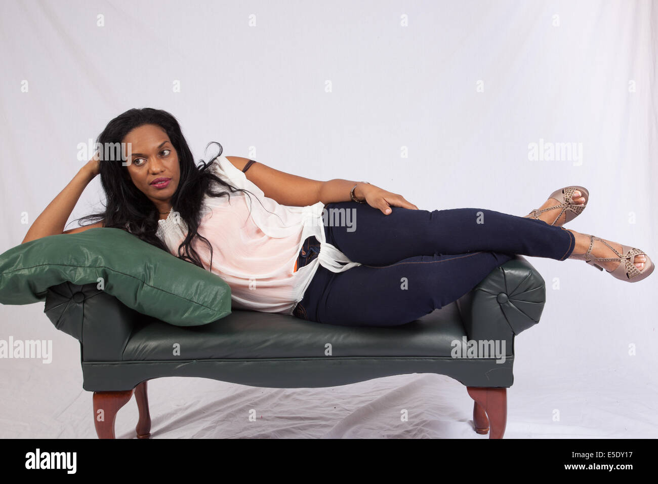 Pretty black woman reclining and looking at the camera  with a friendly,  smile Stock Photo