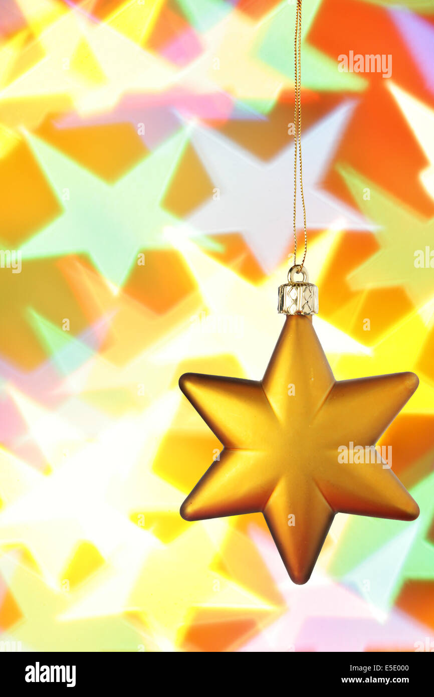 Gold Christmas star close-up over colorful background Stock Photo