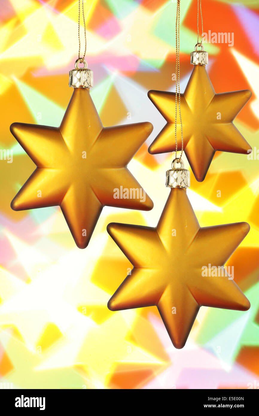 Gold Christmas stars close-up over colorful background Stock Photo