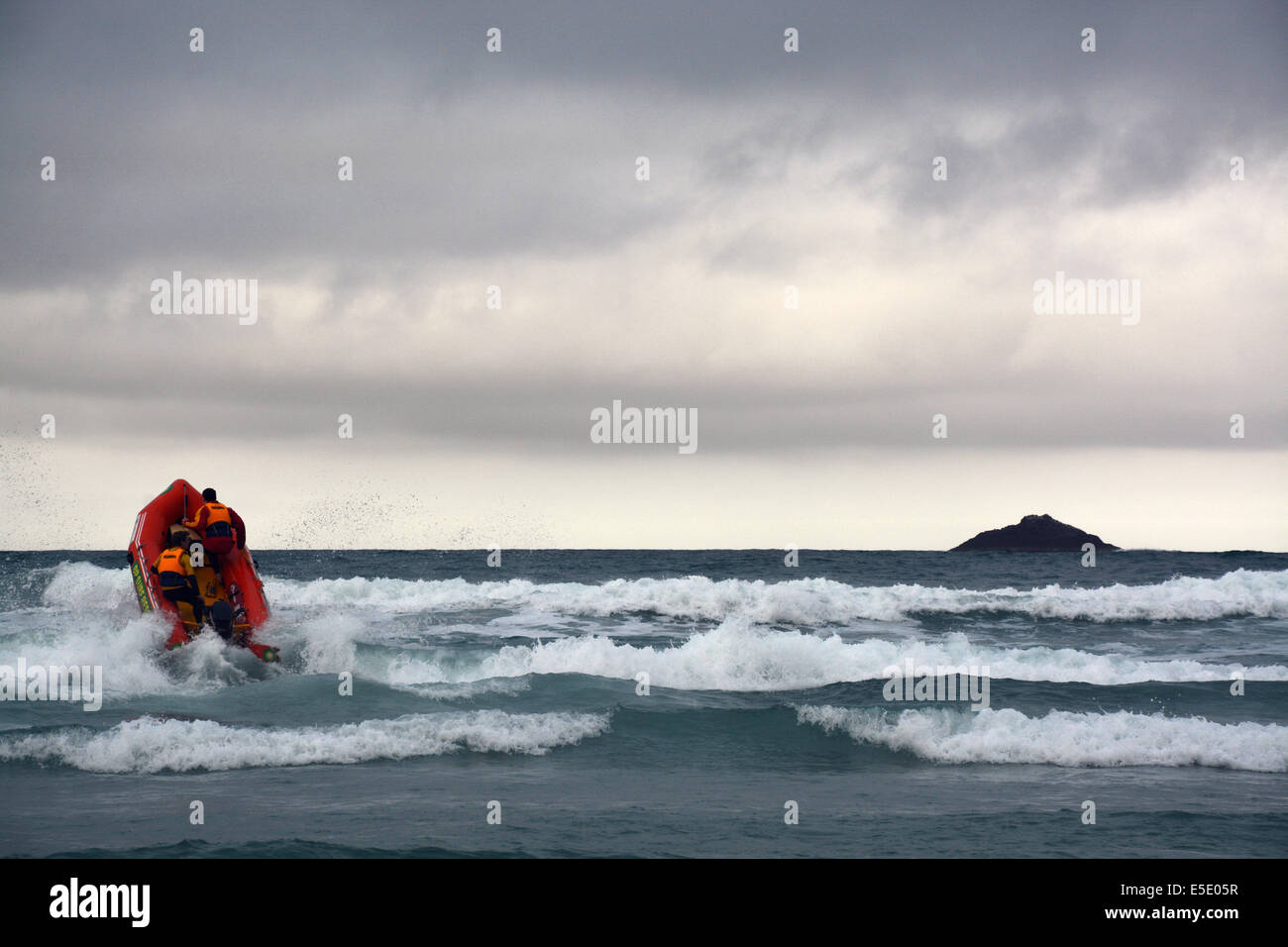 Inflatable boat with 2 lifeguards scouting the coast during Dunedin's annual midwinter Polar Plunge held at St Clair Esplanade Stock Photo