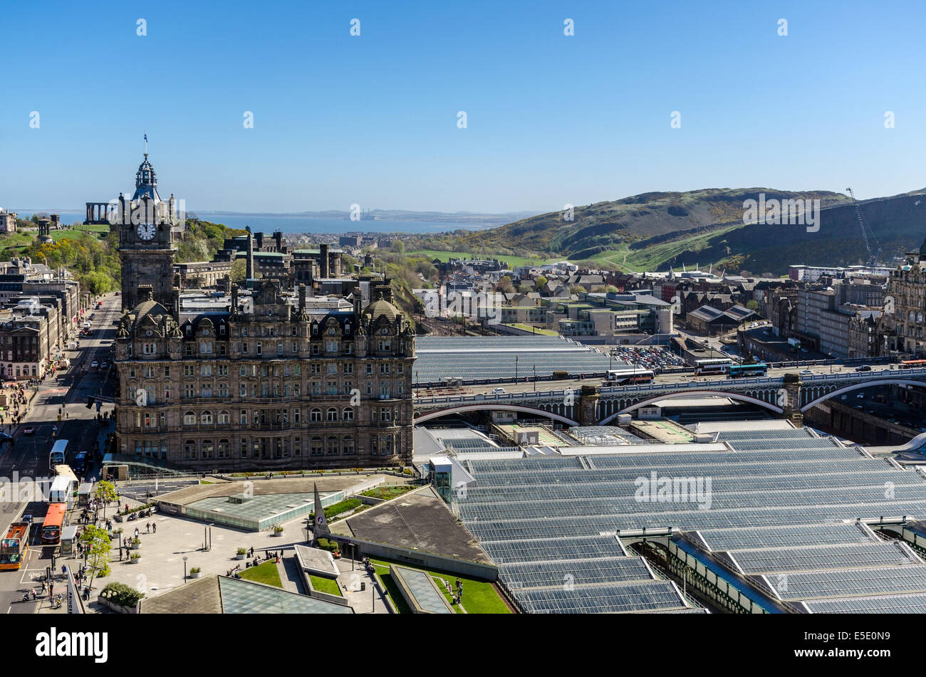 Looking East across Edinburgh to the Balmoral Hotel, Waverley Railway Station, North Bridge, Old Town and Holyrood Park. Stock Photo