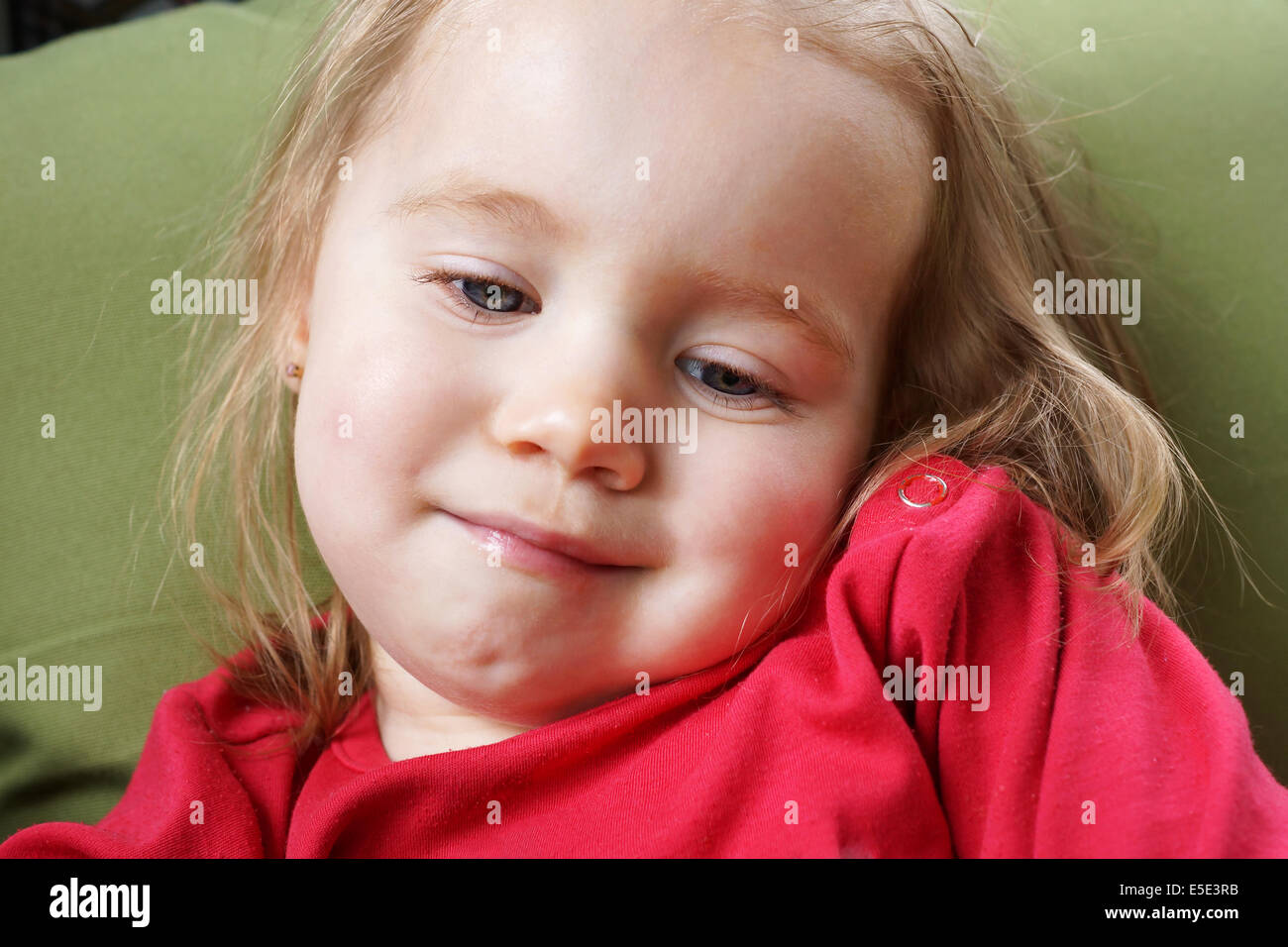 Portrait of a sleepy, smiling, blond baby girl Stock Photo