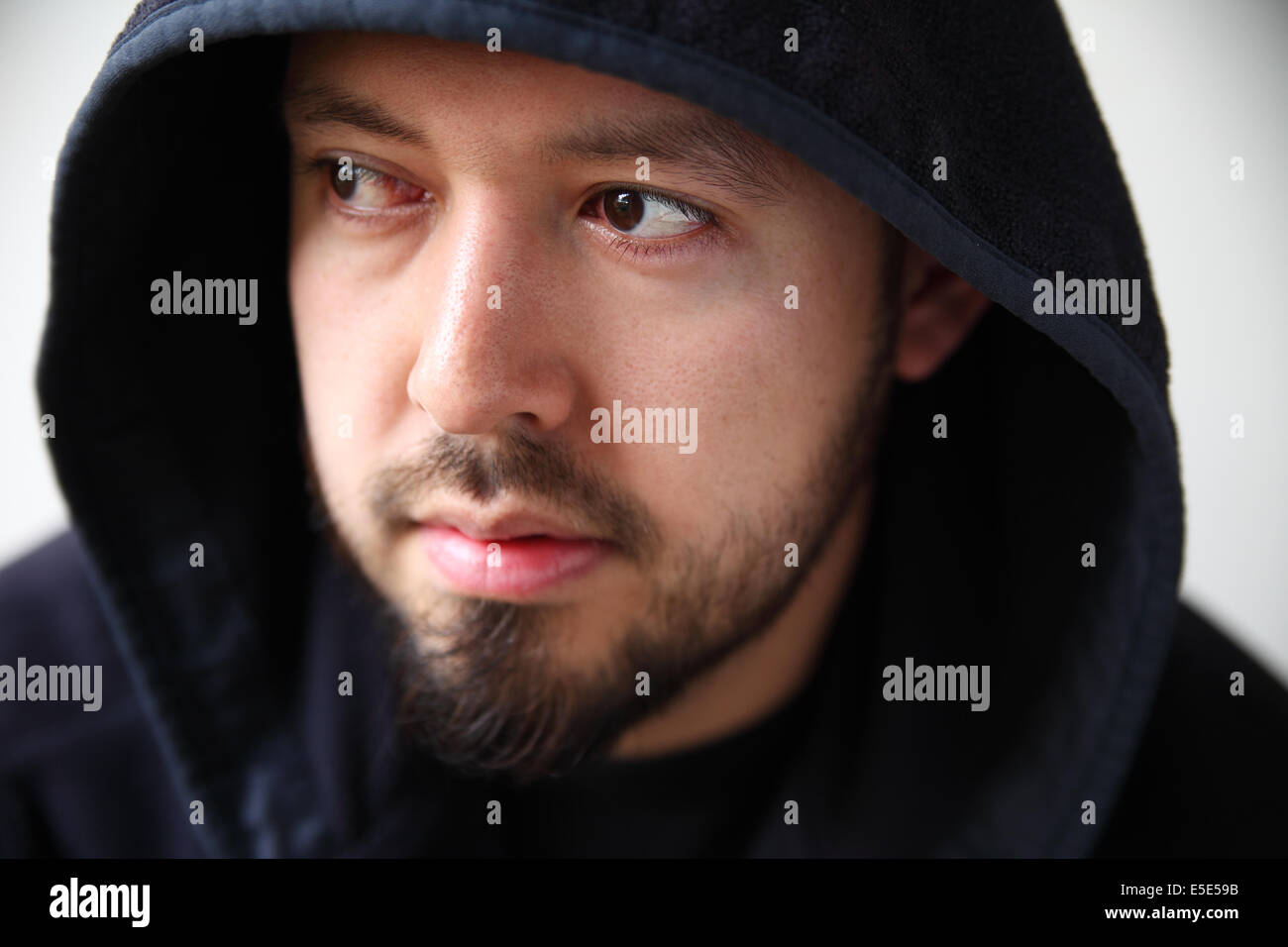 attractive 30-something man in a black hooded jacket Stock Photo