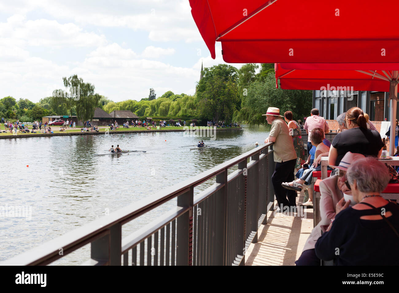 Theatre-goers at the RSC watching a rowing regatta on the River Avon at Stratford upon Avon, Warwickshire UK Stock Photo