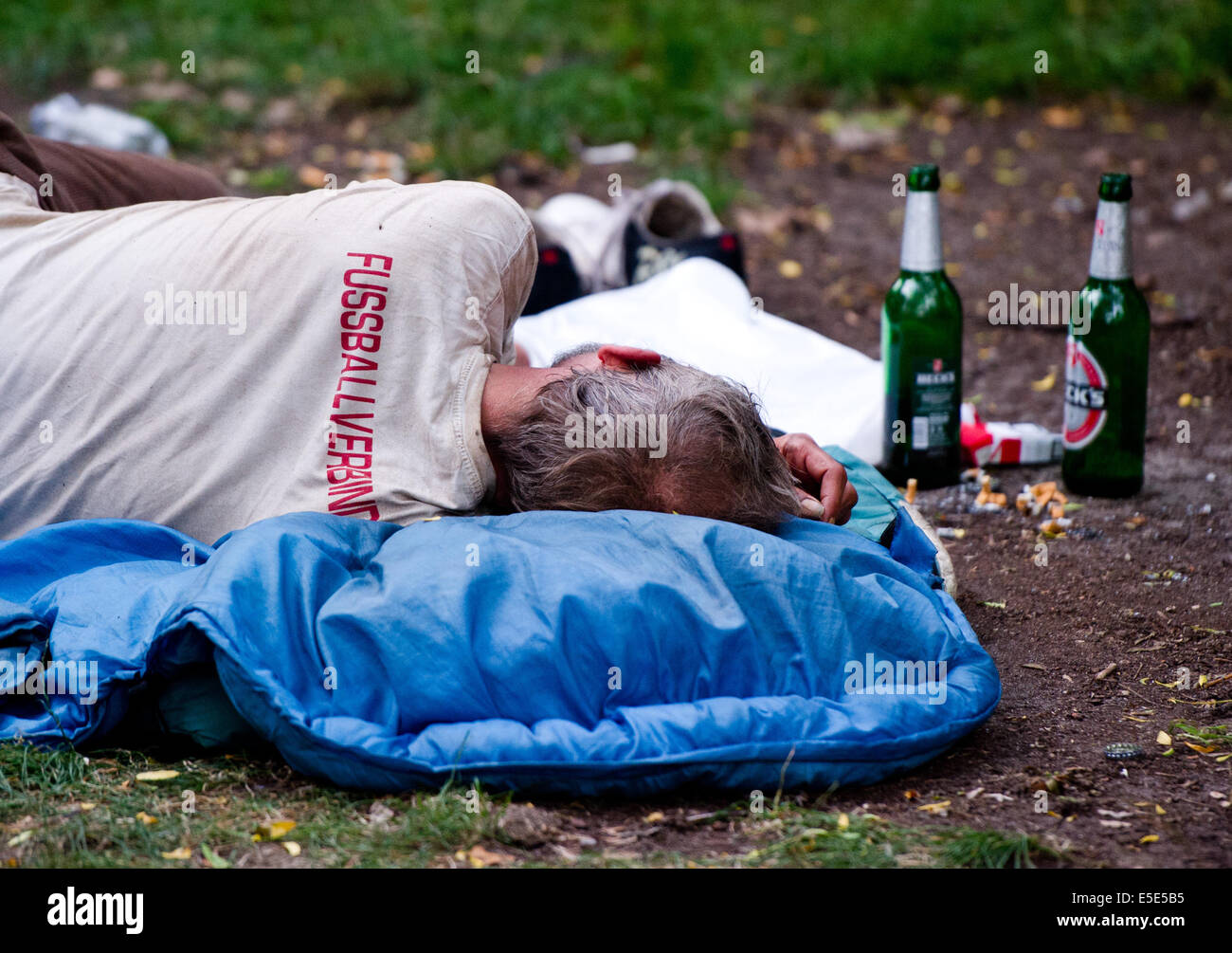Berlin, Germany. 21st July, 2014. A homeless man sleeps next to beer