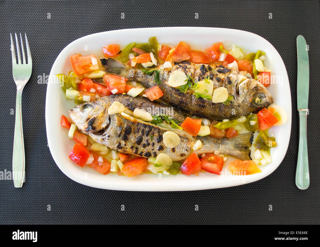 Grilled snappers with mediterranean tomato salad. Typical mediterranean dish. Stock Photo