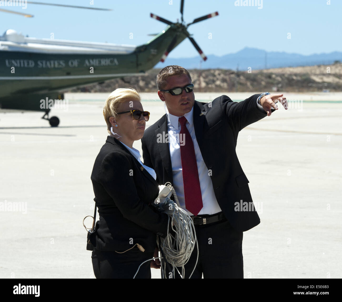 July 23, 2014 - Los Angeles, California, U.S - Marine One --- Marine One on the tarmac at LAX on Wednesday July 23, 2014, as two Secret Service Agents confer before the arrival of President Barack Obama.  Sikorsky's SH-3 Sea King helicopter has been in use by the US Marine Corps' HMX-1 squadron as the first choice for Marine One since not long after it was placed in service by the US Navy in 1961.  The familiar metallic green with white top Sea King is transported, along with the presidential limousine and other large equipment via a set of several C-17 Boeing Globemaster transport aircraft op Stock Photo