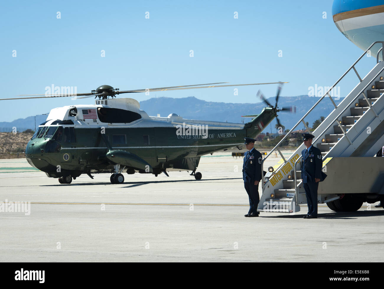 July 23, 2014 - Los Angeles, California, U.S - Marine One --- A Marine One Escort warms up along side Air Force One after the arrival of President Obama at LAX on Wednesday July 23, 2014.  Sikorsky's SH-3 Sea King helicopter has been in use by the US Marine Corps' HMX-1 squadron as the first choice for Marine One since not long after it was placed in service by the US Navy in 1961.  The familiar metallic green with white top Sea King is transported, along with the presidential limousine and other large equipment via a set of several C-17 Boeing Globemaster transport aircraft operated by the US Stock Photo