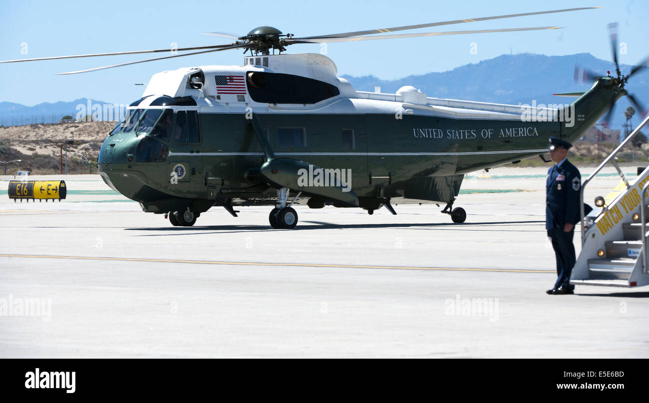 July 23, 2014 - Los Angeles, California, U.S - Marine One --- A Marine One Escort warms up along side Air Force One after the arrival of President Obama at LAX on Wednesday July 23, 2014.Sikorsky's SH-3 Sea King helicopter has been in use by the US Marine Corps' HMX-1 squadron as the first choice for Marine One since not long after it was placed in service by the US Navy in 1961.  The familiar metallic green with white top Sea King is transported, along with the presidential limousine and other large equipment via a set of several C-17 Boeing Globemaster transport aircraft operated by the US A Stock Photo