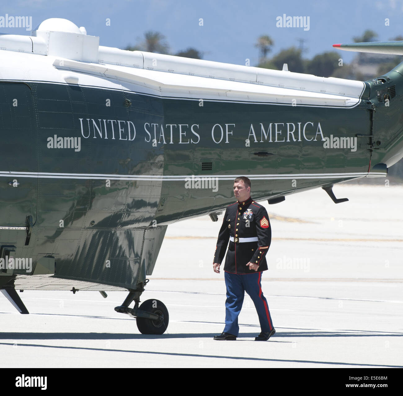 July 23, 2014 - Los Angeles, California, U.S - Marine One --- Marine One on the tarmac at LAX on Wednesday July 23, 2014, as a Marine Sergeant from HMX-1 makes an inspection.  Sikorsky's SH-3 Sea King helicopter has been in use by the US Marine Corps' HMX-1 squadron as the first choice for Marine One since not long after it was placed in service by the US Navy in 1961.  The familiar metallic green with white top Sea King is transported, along with the presidential limousine and other large equipment via a set of several C-17 Boeing Globemaster transport aircraft operated by the US Air Force.   Stock Photo