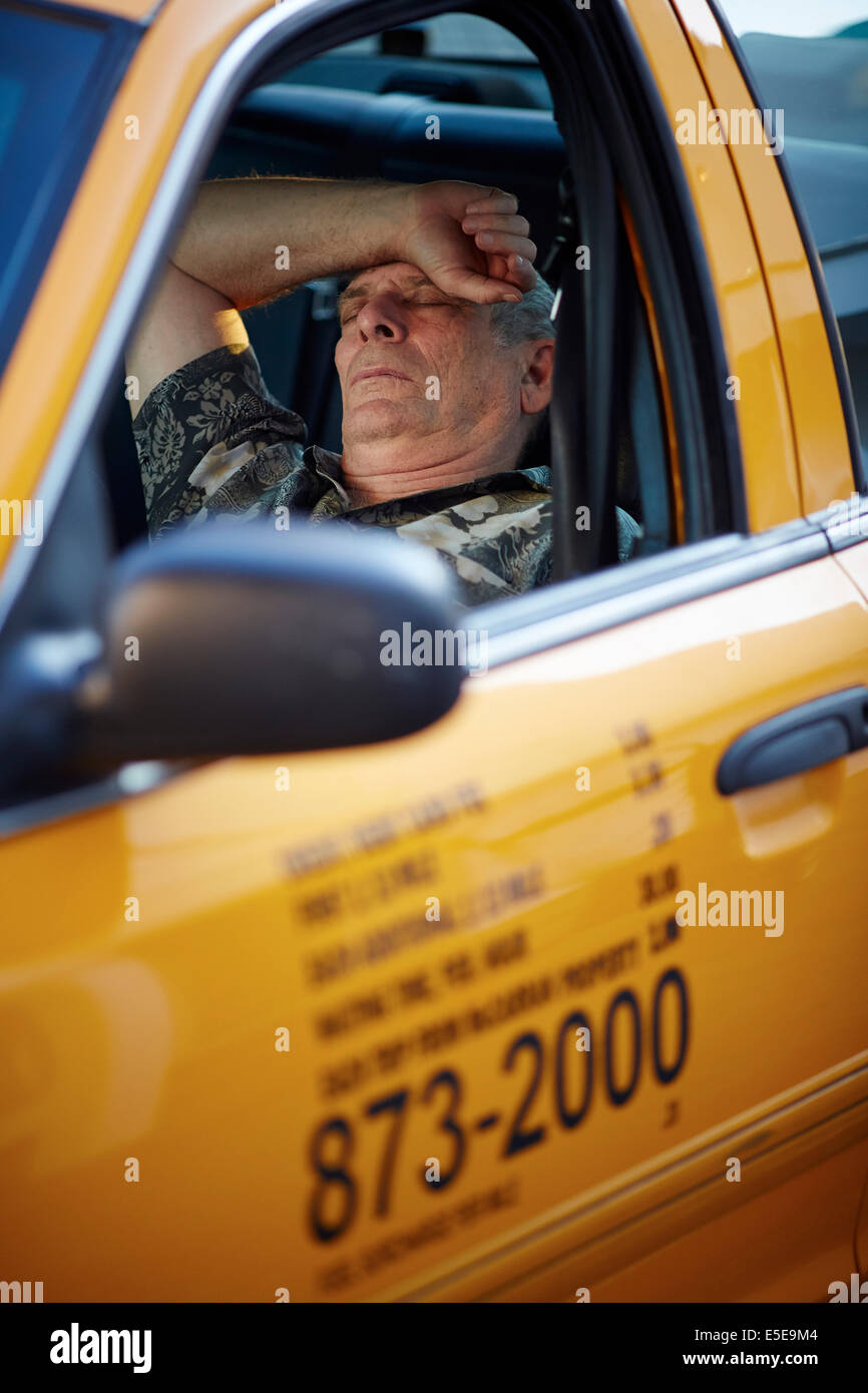Taxi driver sleep between pickups in his yellow cab near the Las Vegas Strip in Paradise, Nevada USA Stock Photo