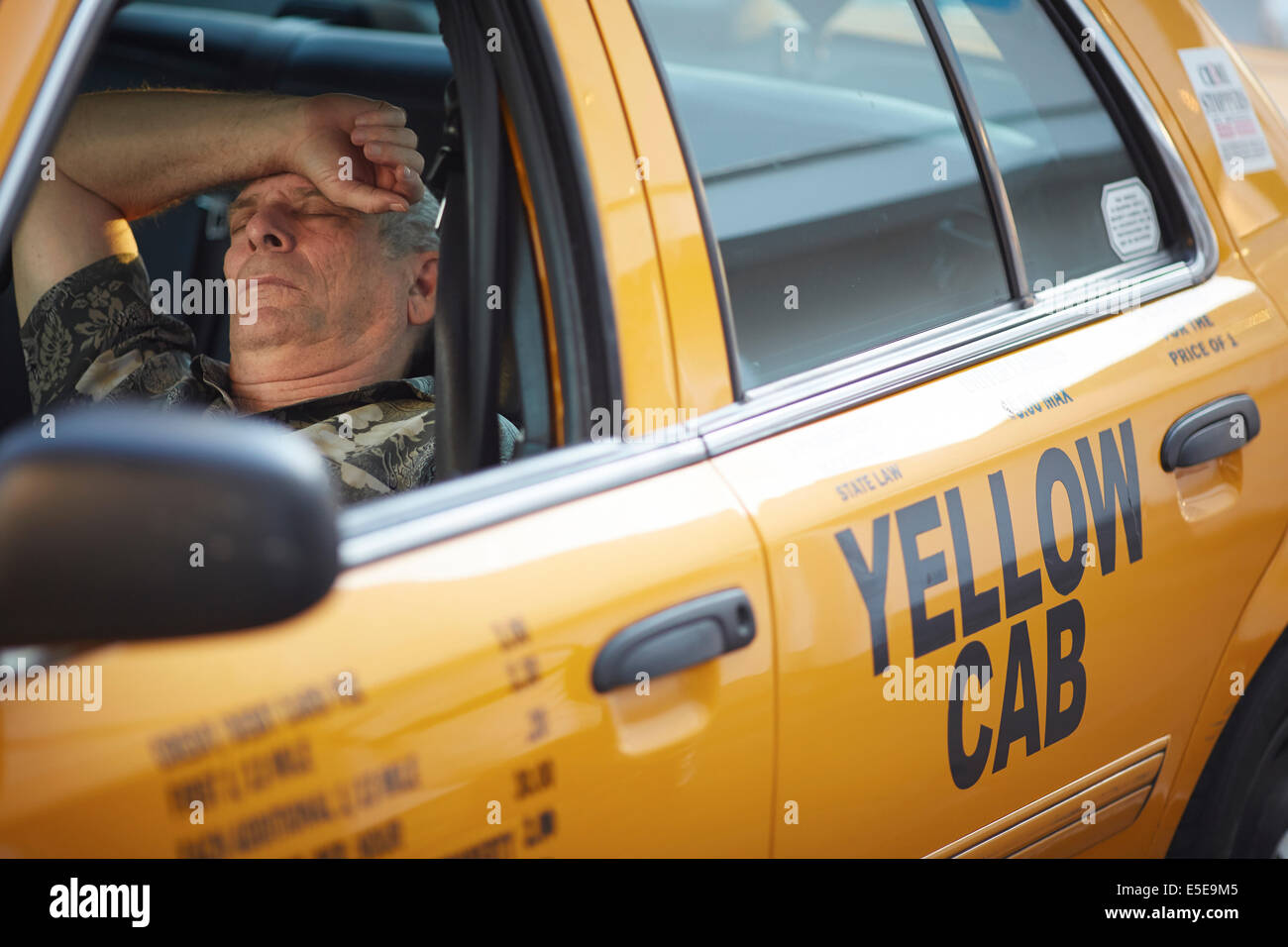 Taxi driver sleep between pickups in his yellow cab near the Las Vegas Strip in Paradise, Nevada Stock Photo