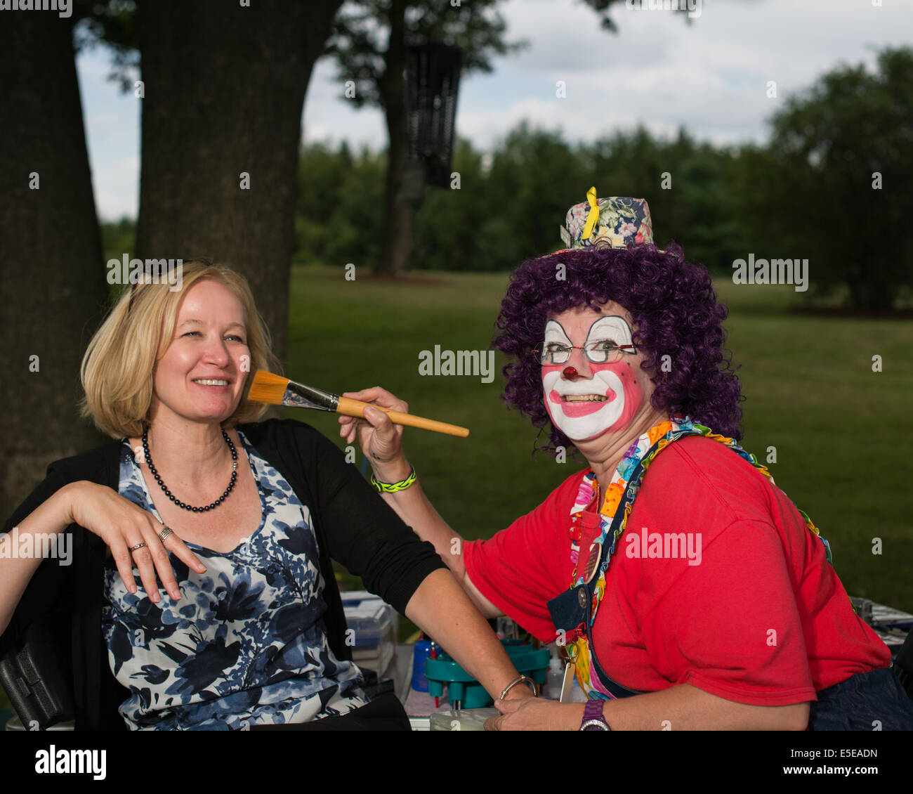 Mrs. Laureen Harper gets painted by Sneezy the Clown at a BBQ for the Milton Conservative Association, in Moffat, Ontario. Stock Photo