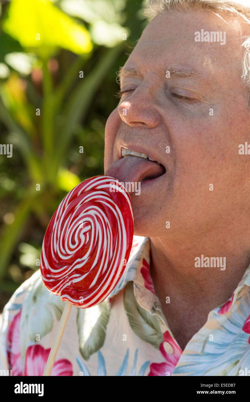 Happy Mature Man Enjoying His Over-sized Lollipop, USA Stock Photo