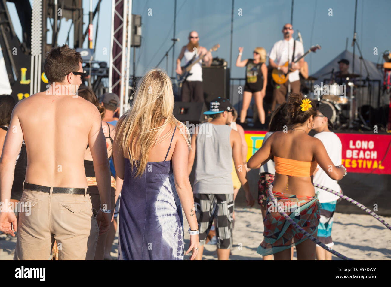 Young people dancing to a live band on stage at a beach music festival
