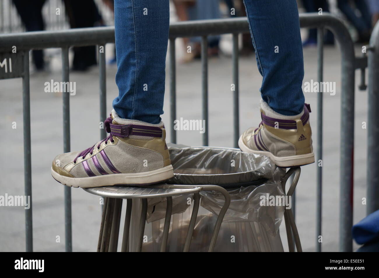 Someone in jeans and Adidas running shoes standing on the hoop of a waste  bag on Avenue des Champs Elysees Paris on Bastille Day Stock Photo - Alamy