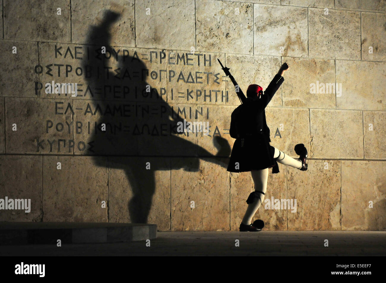 An 'Evzones' soldier in traditional uniform performs an elaborate martial marching routine during the  Sunday evening change of Stock Photo