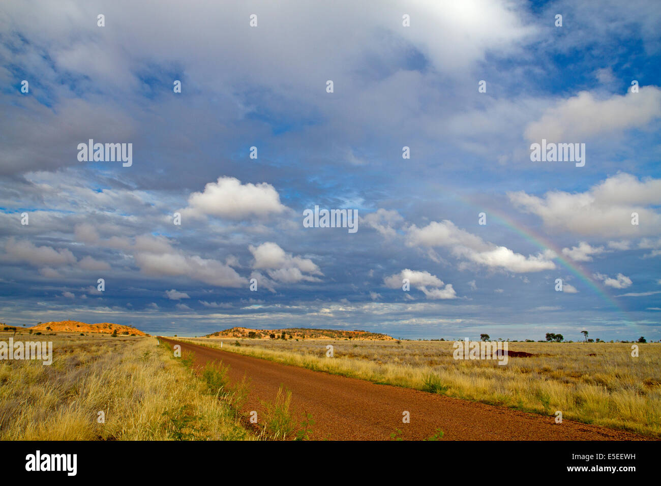 Outback road and rainbow near Longreach Stock Photo