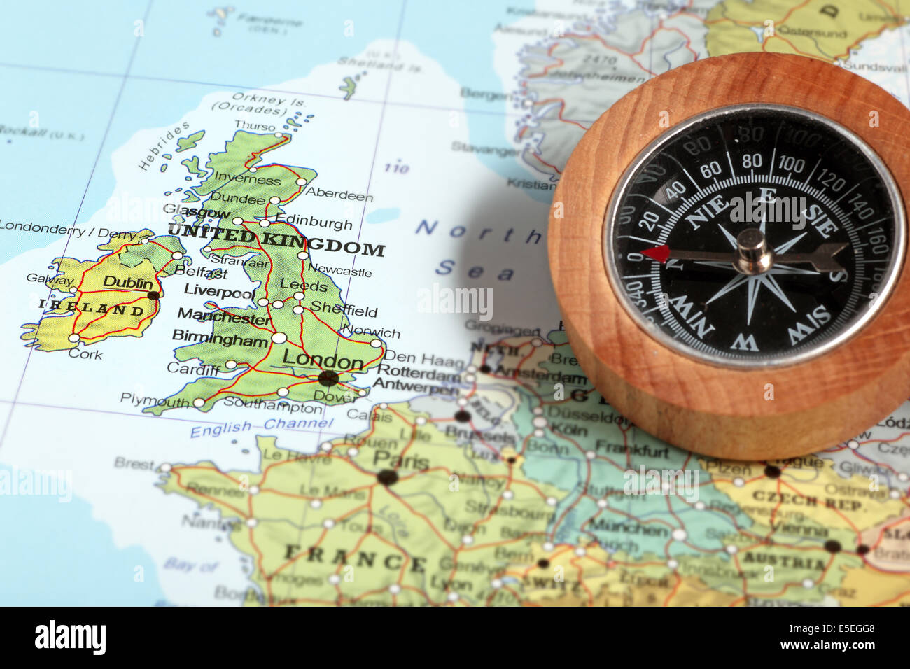 Compass on a map pointing at United Kingdom and Ireland, planning a