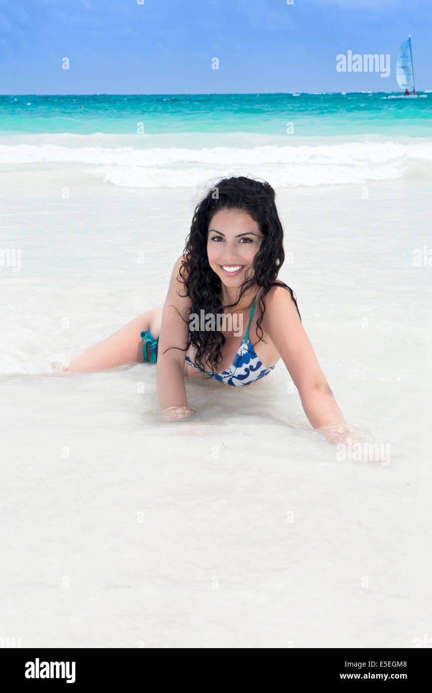 An beautiful young woman in the surf on an idyllic Caribbean beach Stock Photo