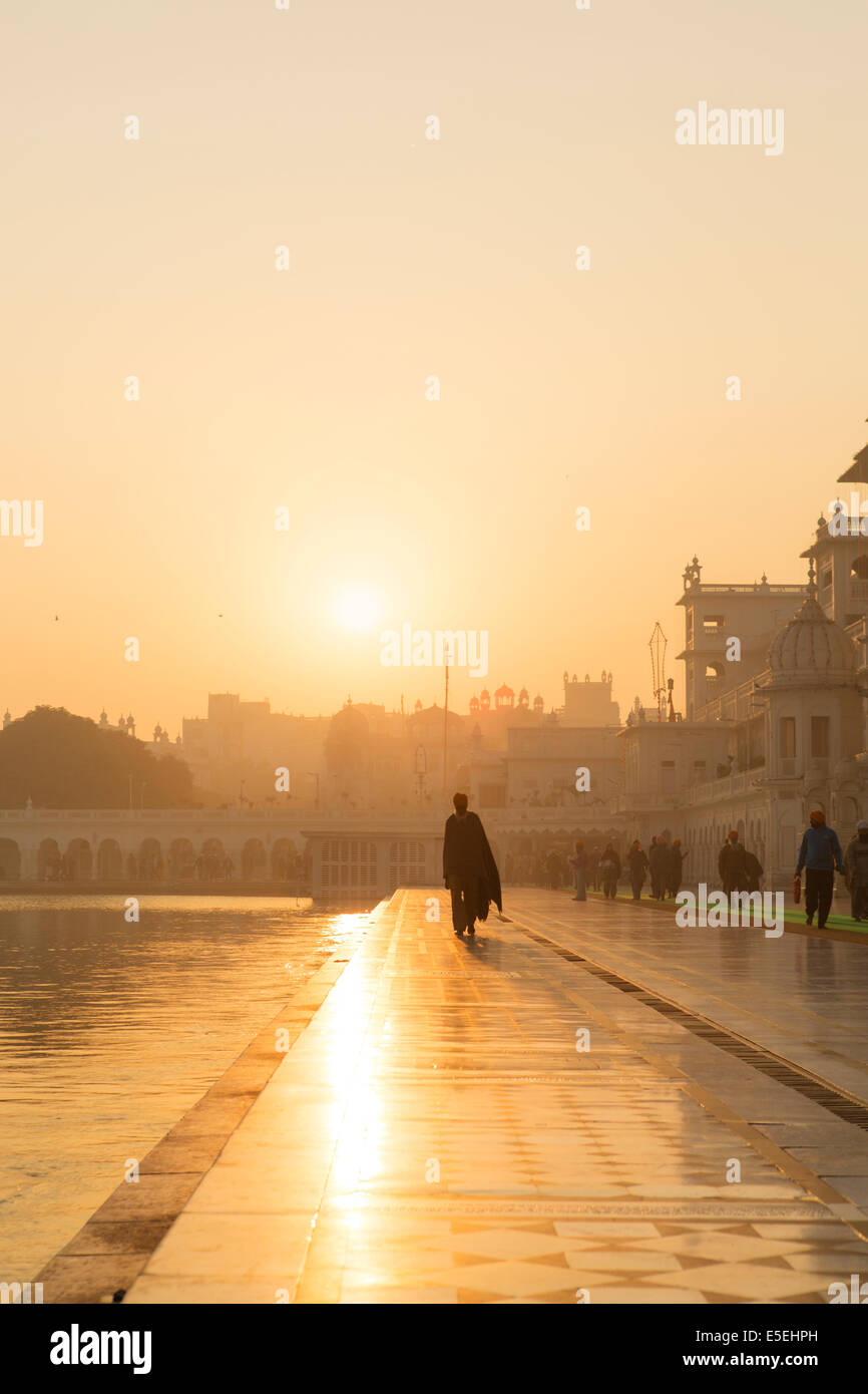 A pilgrim in morning light at the Golden Temple in Amritsar, Punjab, India Stock Photo